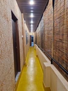 a hallway with a yellow floor in a building at Theglassystay in Raipur +2 photos