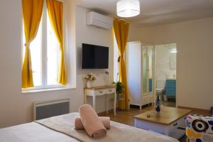 a bedroom with a bed and a television and a bathroom at Hôtes de Saint-Emilion II in Saint-Émilion