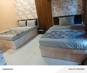 two beds in a hotel room with at Theglassystay in Raipur