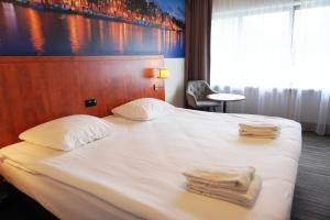 a hotel room with a bed with towels on it at Westlake Hotels Amsterdam in Amsterdam