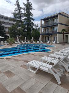 a swimming pool with lounge chairs and a hotel at Sol e Mar in Sunny Beach