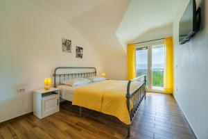 a bedroom with a bed and a tv on a wall at Holiday house Gloria in Vrbnik +18 photos