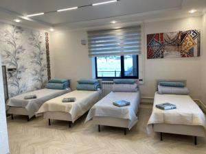 a hospital room with four beds and a window at Tunduk Lux House in Teploklyuchinskoye