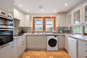 a kitchen with white cabinets and a dishwasher at Castle Peroch in Dunkeld