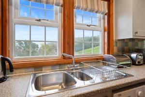 a kitchen with a sink and two windows at Castle Peroch in Dunkeld