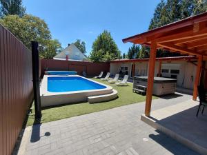 a backyard with a swimming pool and a fence at Borti Apartman in Zamárdi