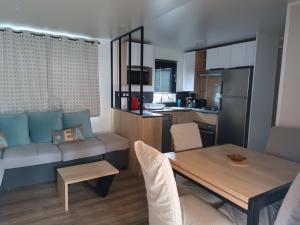 a kitchen and living room with a table and a couch at Lesoleil in Canet-en-Roussillon