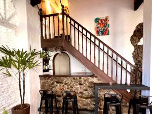 a staircase in a room with chairs and a table at Hotel Los Pinos in Colonia del Sacramento