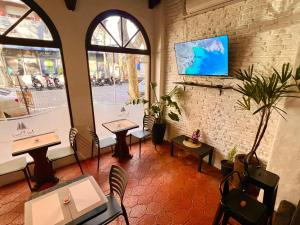 a restaurant with tables and chairs and a window at Hotel Los Pinos in Colonia del Sacramento