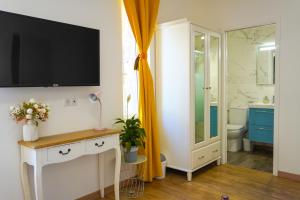 a bathroom with a toilet and a television on a wall at Hôtes de Saint-Emilion II in Saint-Émilion +86 photos