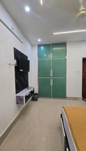 a large room with a green door and a tv at S J RESiDENCY in Trivandrum