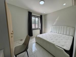 a bedroom with a white bed and a chair at Ashmita Shahi House in Kathmandu