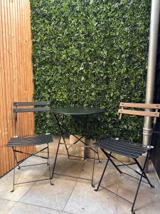 two chairs and a table next to a hedge at Zeeuws Ontspannen - Privé Wellness & Suites in Middelburg +2 photos