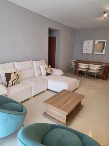 a living room with a white couch and a table at C7 double up in Camama