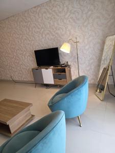 a living room with a blue chair and a desk at C7 double up in Camama