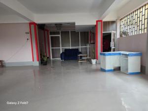 a large room with a white floor and red walls at Riverview greenstar homes in Kisii