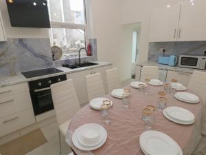 a kitchen with a table with plates and glasses on it at 5 Gelli Terrace in Caerphilly +19 photos