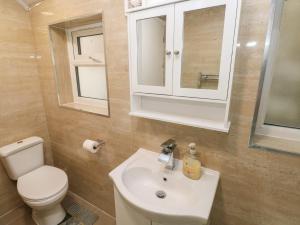 a bathroom with a sink and a toilet and a mirror at 5 Gelli Terrace in Caerphilly