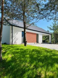 a red brick building with a black roof at Przystanek Nowa Ruda in Ślesin