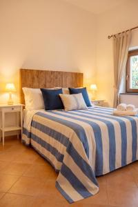 a bedroom with a large bed with blue and white stripes at Casa della Marina - beach, seaview, wifi in Conca dei Marini