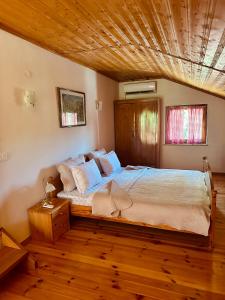 a bedroom with a large bed with a wooden ceiling at Kuća za odmor Srce in Slavetić