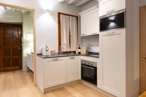 a kitchen with white cabinets and a microwave at La Piccola Atene Atelier in Pietrasanta +21 photos