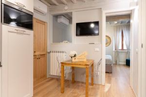 a small room with a table and a tv on the wall at La Piccola Atene Atelier in Pietrasanta