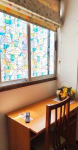 ein Fenster mit einem Schreibtisch, auf dem eine Fernbedienung liegt in der Unterkunft Hostal J.B in Malpica