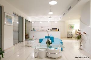 a living room with blue chairs and a glass table at Grand Boutique in Vasiliki