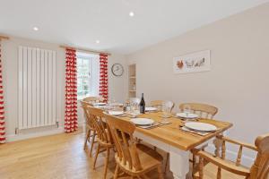 a dining room with a wooden table and chairs at Brandoch Lodge in Logierait