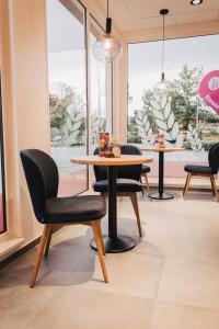 a dining room with a table and chairs and windows at Modern Apartment 1 Graf - New! in Grafenwöhr