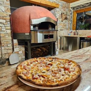 a pizza sitting on a table in front of an oven at Hotel Duc De Rohan in Livigno
