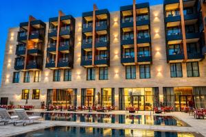 a hotel with a pool in front of a building at Hotel Deauville El jadida in El Jadida