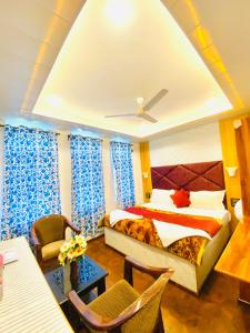 a hotel room with a bed and a table and chairs at Rahat Resort in Srinagar
