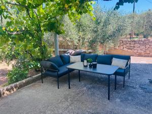 a blue couch and two chairs and a table at Apartments Tomas in Ugljan
