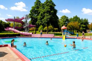 a group of children playing in a swimming pool at Steam & Dream - Hottub & Sauna Retreat - Free WiFi - Full Privacy - Luxury Experience in Heinkensand