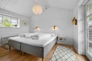 a bedroom with a bed in a room with white walls at LN1926-Hjorring-Jollevej-2 in Hjørring