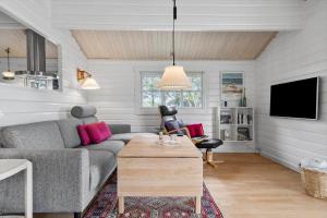a living room with a couch and a tv at LN1926-Hjorring-Jollevej-2 in Hjørring
