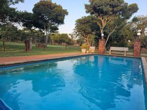 a large blue swimming pool in a park at Buyskop Lodge, Conference & Spa in Bela-Bela +18 photos