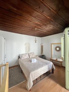 a bedroom with a bed with a wooden ceiling at Happiness skopelos in Glossa