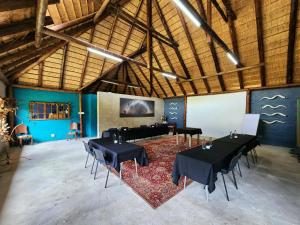 a large room with black tables and chairs in it at Buyskop Lodge, Conference & Spa in Bela-Bela