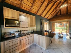 a kitchen with wooden cabinets and a counter top at Buyskop Lodge, Conference & Spa in Bela-Bela
