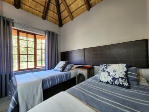 a bedroom with two beds and a window at Buyskop Lodge, Conference & Spa in Bela-Bela