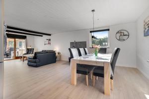 a dining room and living room with a table and chairs at Feriehus 1149 in Ringkøbing +25 photos