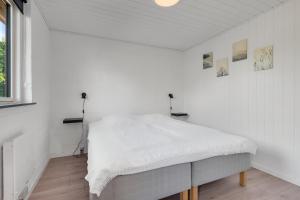 a white room with a bed in the corner at Feriehus 1149 in Ringkøbing