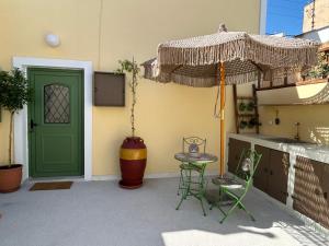 a patio with a green door and a table and chairs at Floura's Kamariko - Authentic Rhodian Village House in Archangelos