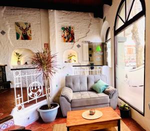 a living room with a couch and a table at Hotel Los Pinos in Colonia del Sacramento