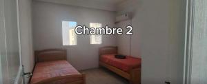 a room with two beds and a sign that says chambride at Dar Tantana sayafi in Hammam Sousse