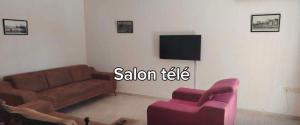 a living room with a couch and a tv at Dar Tantana sayafi in Hammam Sousse