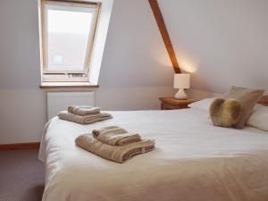 a bedroom with two towels on a bed with a window at Chive - E4326 in Catfield